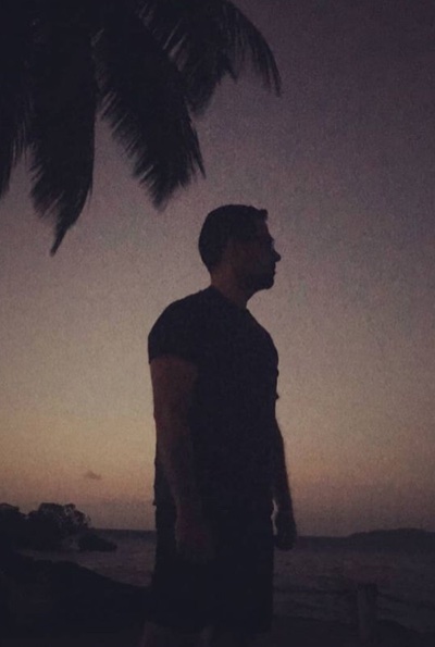 Sergei Liebich silhouetted against a sunset at the beach